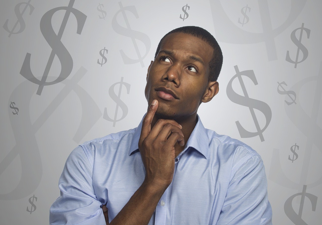 puzzled man surroundedby dollar signs