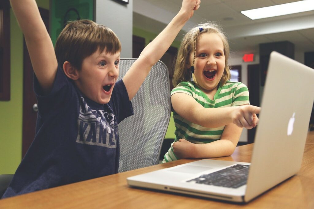 2 happy kids on laptop