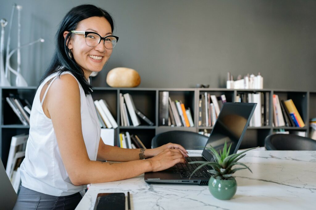 Happy Asian woman on laptop