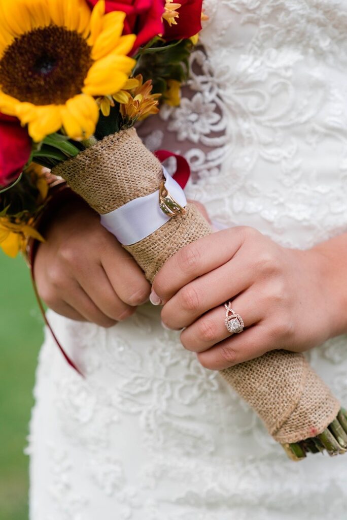 Bride wears a diamond ring and carries sunflower bouquet. Pixabay