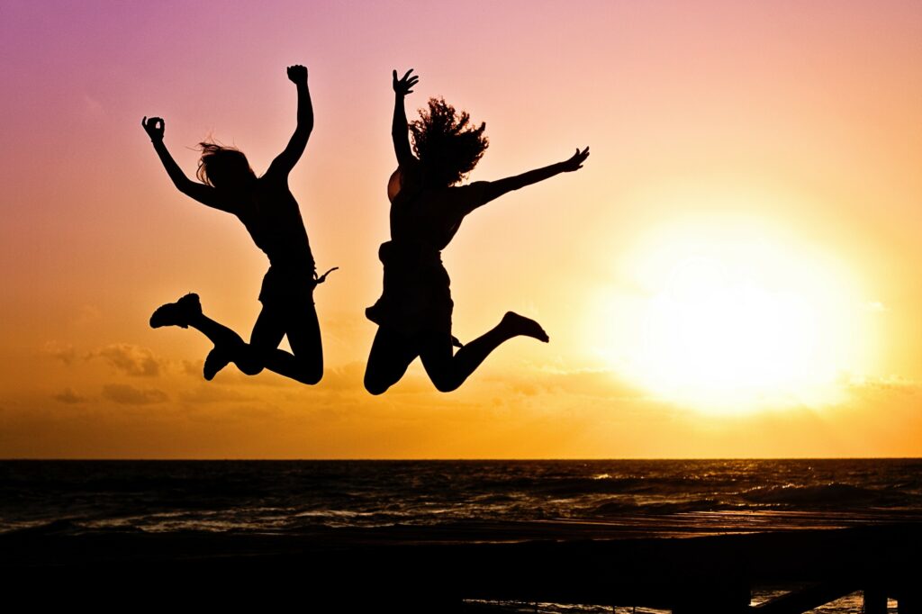 happy people jumping at sunset