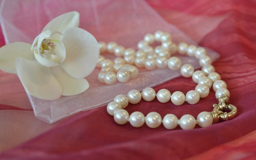 white pearl necklace and white flower