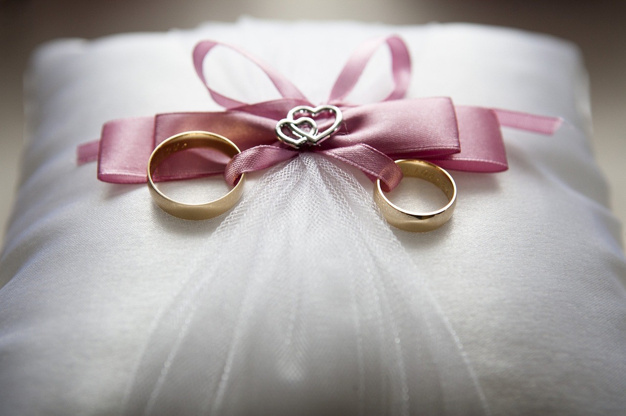 Two wedding rings tied to a ring bearer's pillow Pixabay.com