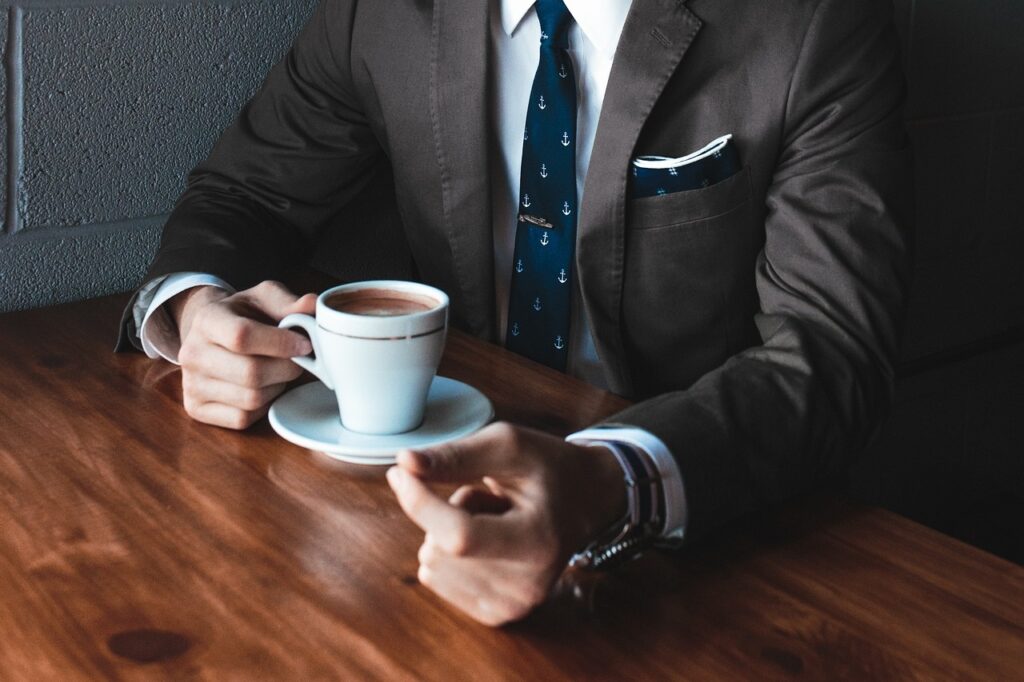 man in dark suit white handkerchief coffee PXBY