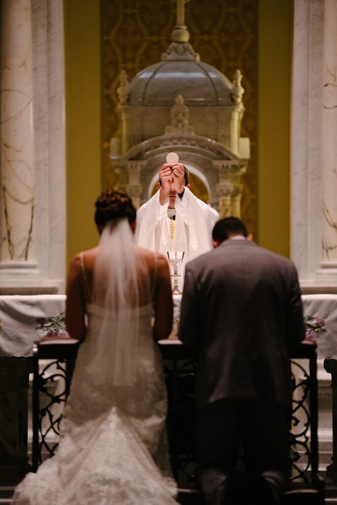 Roman Catholic priest offers communion during a wedding Pixabay