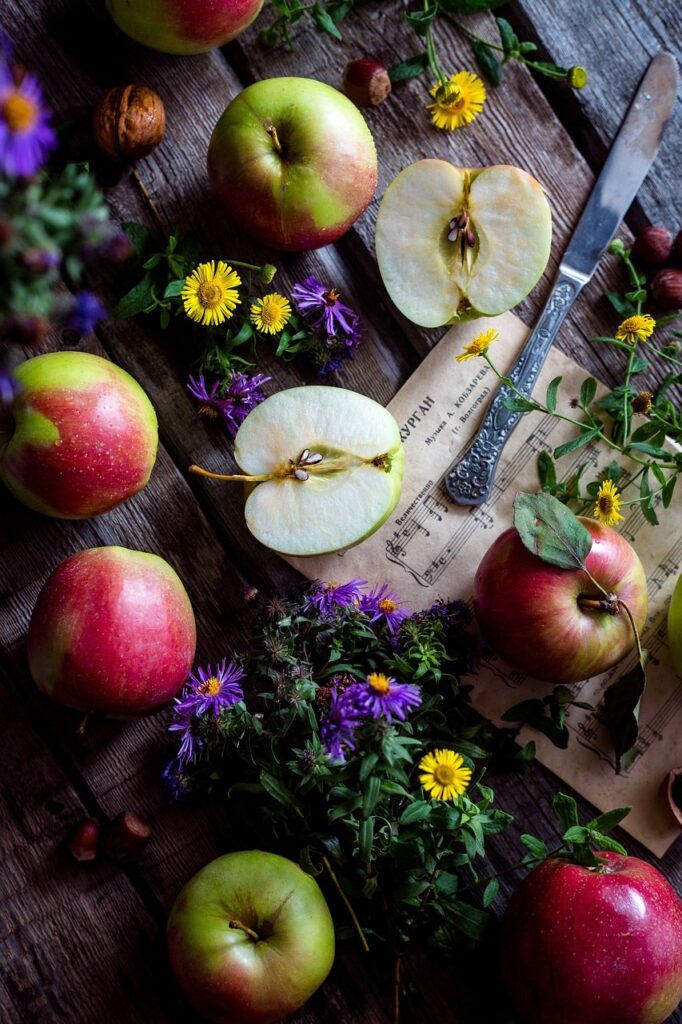 a table of apples and flowers Pixabay