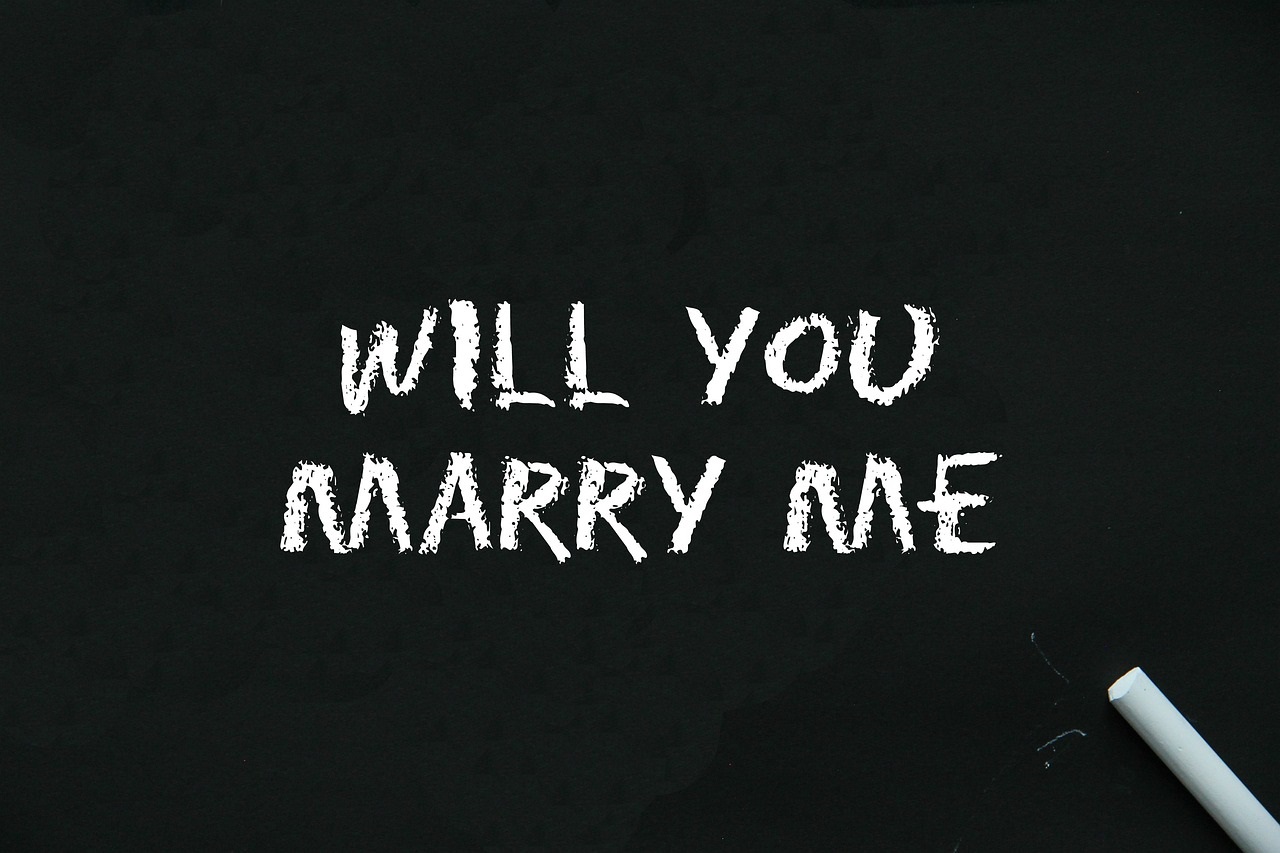 Will you marry me? is written on a black chaklboard Pixabay