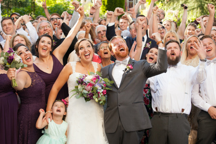 Happy newly weds and guests posing with exclamatory expressions at the Ainsworth House