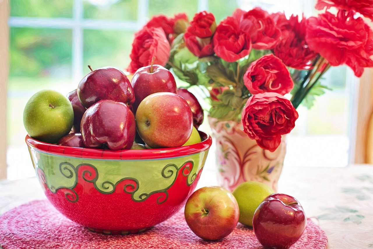 apples in a bow and flowers in a vase