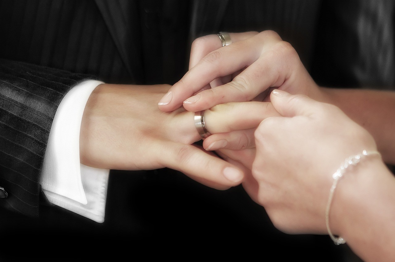 Bride places ring on groom's finger