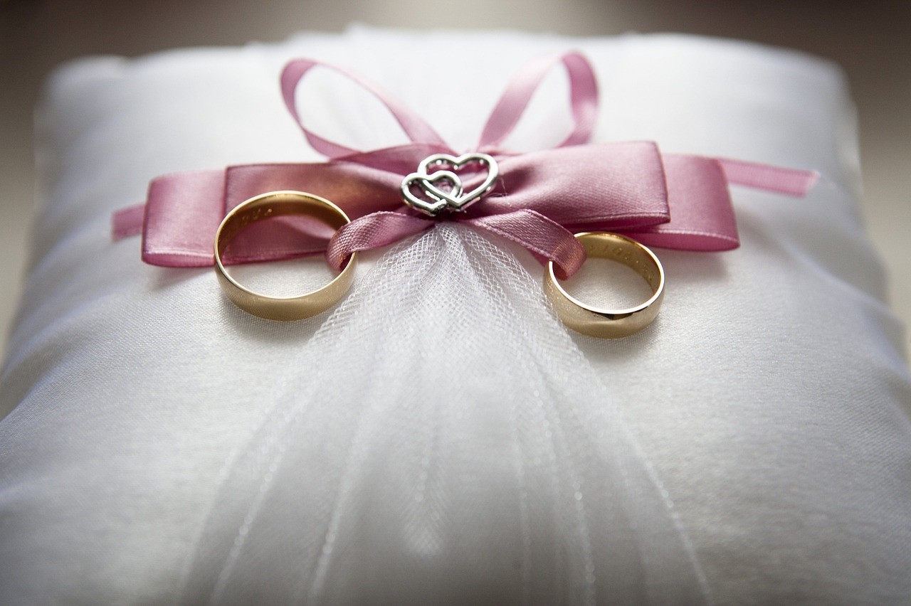 Two wedding rings tied to a ring bearer's pillow