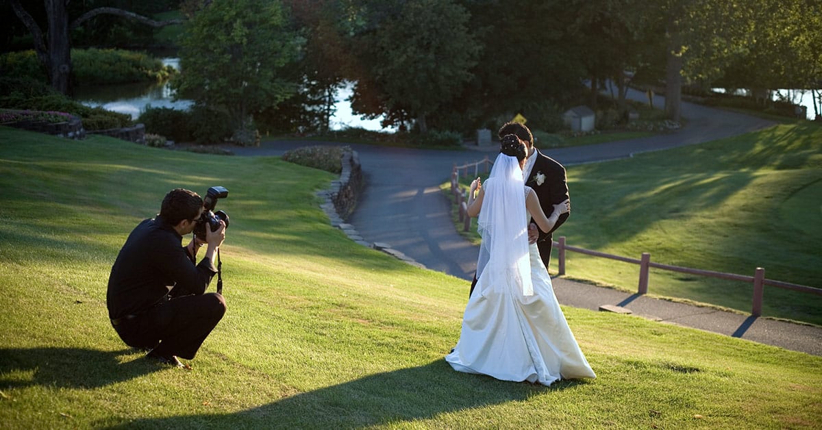 wedding photographer taking photo on lawn