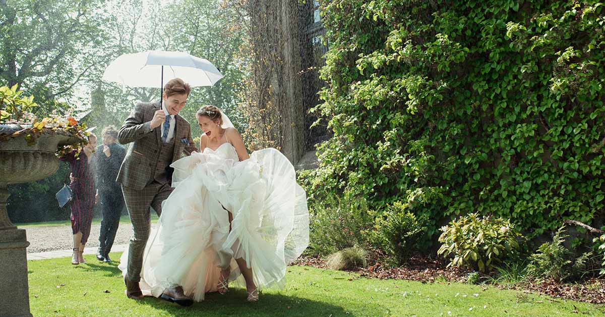Outdoor Oregon wedding in rain with umbrella